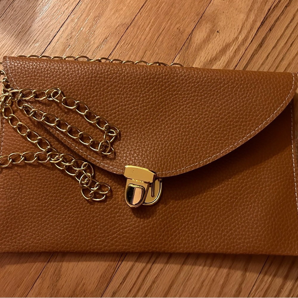 Brown crossbody bag with gold chain.